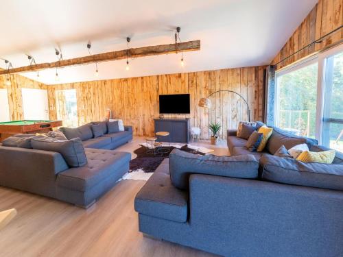 维尔茨费尔德Lush chalet near lake of B tgenbach的客厅配有蓝色的沙发和电视