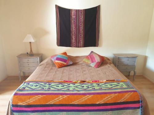 CodpaAruma Codpa的一间卧室配有一张带两张桌子和毯子的床