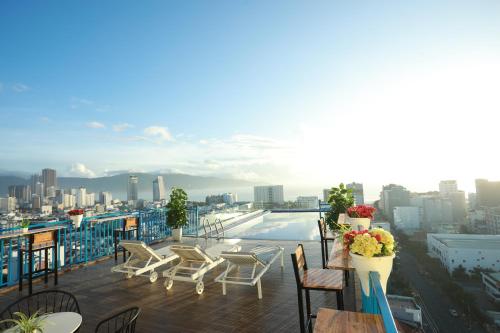 岘港FIVITEL King的阳台配有桌椅,享有城市美景。