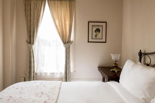 汤森港The Bishop Hotel的卧室配有白色的床和窗户。