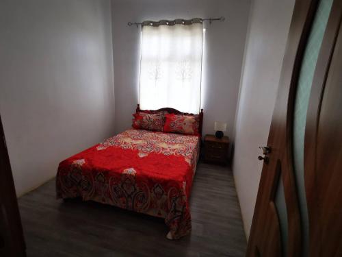 Petite RivièreRésidence Oak的一间卧室配有一张带红色棉被的床和窗户。