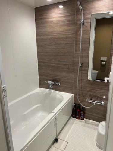 大阪HOTEL GrayⅡ的浴室配有浴缸、淋浴和镜子