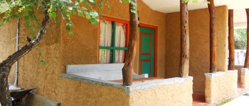 波隆纳鲁沃克雷哈特村住宿加早餐旅馆的一座有绿色和红色门和树木的建筑