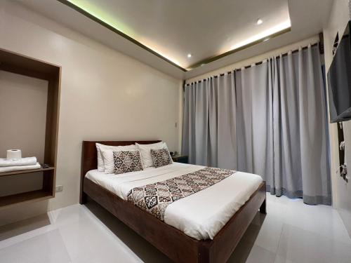 爱妮岛Bulul Garden Resort的一间卧室设有一张床和一个大窗户