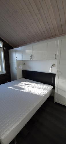 法伦Lakeside log cabin Främby Udde Falun的天花板客房内的一张白色床