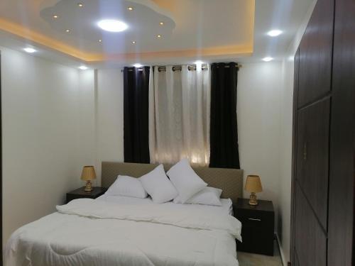 瓦迪穆萨Petra Guests home的卧室配有白色的床和黑色窗帘