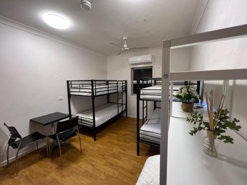 班达伯格Tomato Backpackers的客房设有三张双层床、一张桌子和一张书桌。