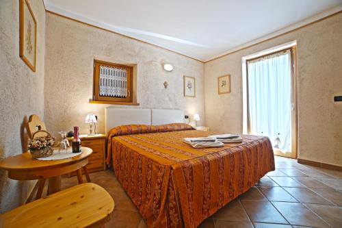 圣斯泰法诺达韦托Residence Grand Hotel SIVA - Adults Only的一间卧室配有一张床、一张桌子和一个窗户。