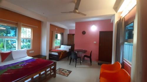 蒙纳Himadri munnar holidays的卧室配有一张床和一张桌子及椅子