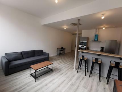 蒙索莱米讷10 rue Carnot的客厅配有沙发、桌子和凳子