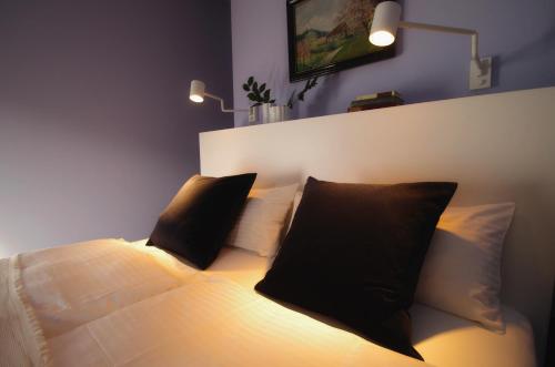 纽伦堡quartier26的一间卧室配有一张带两个黑色枕头的床
