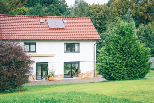 JurkówLipolas-slowlife&guesthouse的一座带太阳能屋顶和庭院的白色房子