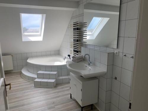 埃森Schöne Ferienwohnung im Dachgeschoss的白色的浴室设有浴缸和水槽。