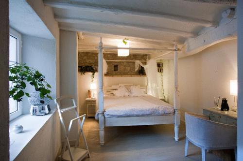 OlloHotel El Secreto de Ollo的一间卧室配有天蓬床和桌椅
