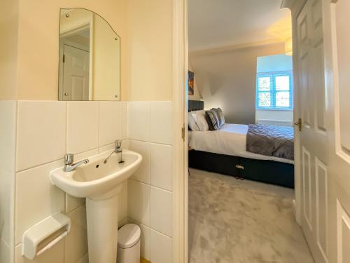 坎特伯雷The Copperfield - Modern 4 Bed house with parking的一间带水槽的浴室和一间带一张床的卧室
