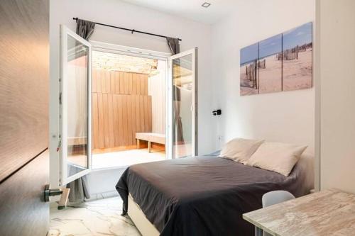 巴达洛纳Apartamento en Planta Baja en Badalona的一间卧室设有一张床和一个滑动玻璃门