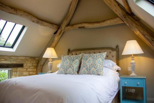 赛伦塞斯特The Potting Shed, 5* Luxury escape Cirencester的卧室配有带两盏灯的白色床