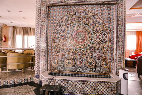 阿尤恩nagjir centre ville的带浴缸的客房内的大瓷砖墙