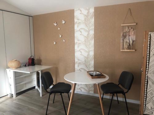 图卢兹Au Petit C'Alain的一间用餐室,配有桌椅,墙上有鸟类