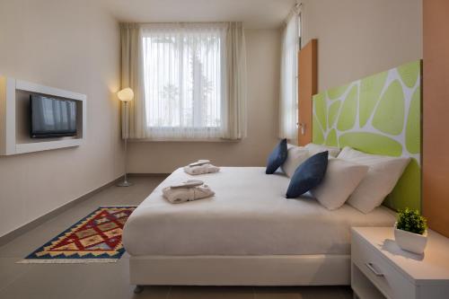 耶鲁姆Desert Iris Hotel的一间卧室配有一张大床和电视