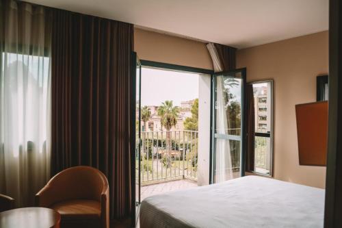 卡塞塔Hotel dei Cavalieri Caserta - La Reggia的酒店客房设有一张床和一个大窗户