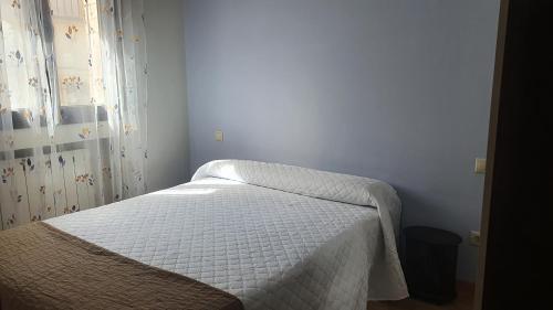 Apartamento "La Casita de Teresa"的一间卧室配有一张带白色床罩的床
