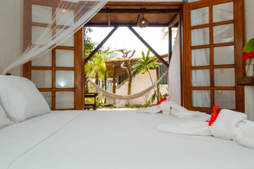 托兰克索Travel Inn Trancoso Suítes的卧室配有白色的床和窗户。