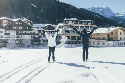 盖洛斯DAS GERLOS - Boutique Hotel的两个人站在雪地里,手臂挺起来