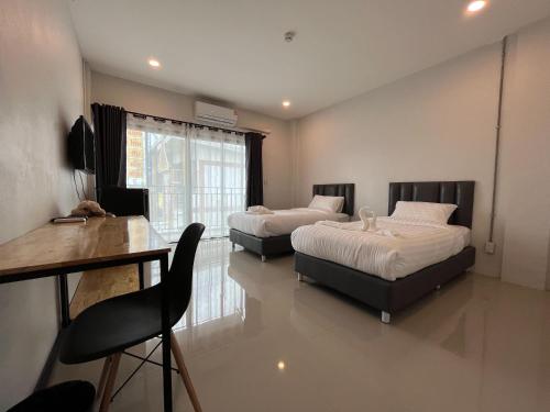 Ban MaiLife Hotel Rong Khun的一间卧室配有两张床、一张桌子和一张书桌
