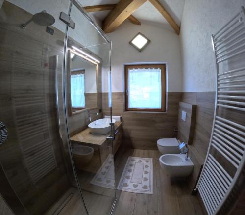 博尔米奥卡萨贝蒂公寓的一间带两个盥洗盆、淋浴和卫生间的浴室