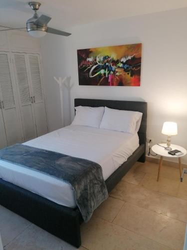 卡塔赫纳Cabrero Beach 1111的卧室配有一张床,墙上挂有绘画作品