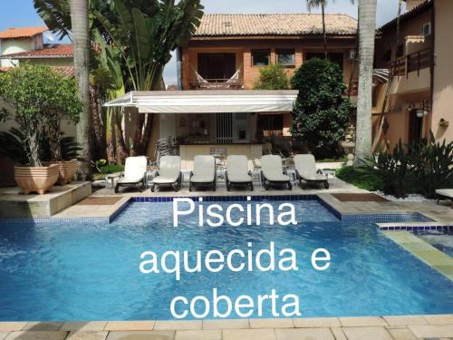 瓜鲁雅Hotel Costa Balena-Piscina Aquecida Coberta的一个带读过比萨科镇痛药的标志的度假游泳池