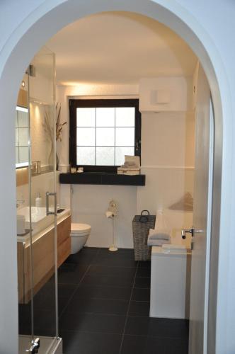 尼德根Ferienwohnung Rureifel的一间带水槽和卫生间的浴室以及窗户。