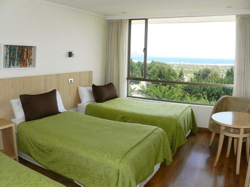 康康Mantagua Village的酒店客房设有两张床和大窗户。