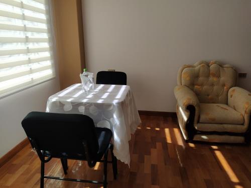 科帕卡巴纳Hostal Alvasar的客厅配有桌子和两把椅子
