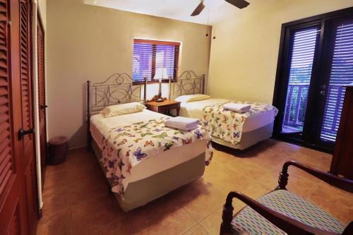 圣地亚哥Suite Granada 131 Gran Pacifica Resort的一间卧室设有两张床、一把椅子和窗户。