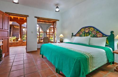 帕茨库卡罗利克希生态酒店的一间卧室,卧室内设有一张绿色大床