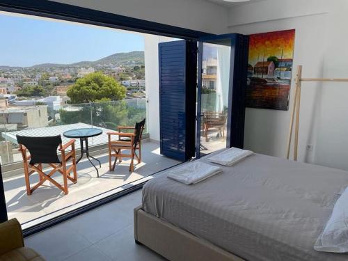 VathíSouvala /Aegina. Excellent location Luxury villa.的一间卧室配有一张床,阳台配有桌椅