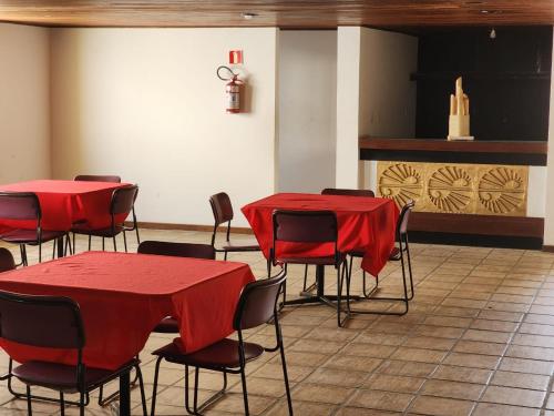 萨尔瓦多Apartamento único na praia do Farol de Itapuã的一间设有红色桌椅和壁炉的客房