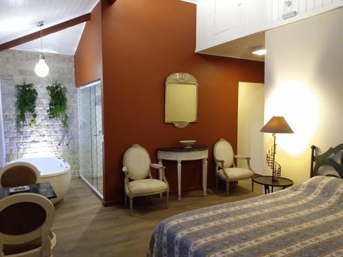 伊泰帕瓦Pousada Quinta do Alto的一间带浴缸和床的卧室以及一间浴室。