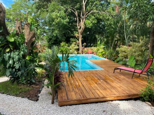 塔马林多Casa Mapache的游泳池旁带椅子的木甲板