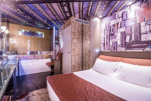 巴黎阿伯斯特洛福酒店的一间卧室配有一张床、一个浴缸和一个水槽