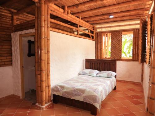 里韦拉Villa Jardines de la Monarca的一间带一张床的卧室,位于带木制天花板的房间内