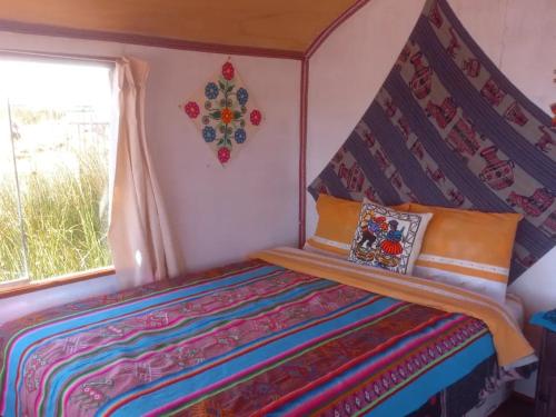 普诺Uros Titicaca Khantaniwa Lodge的一间小卧室,配有一张带天蓬的床