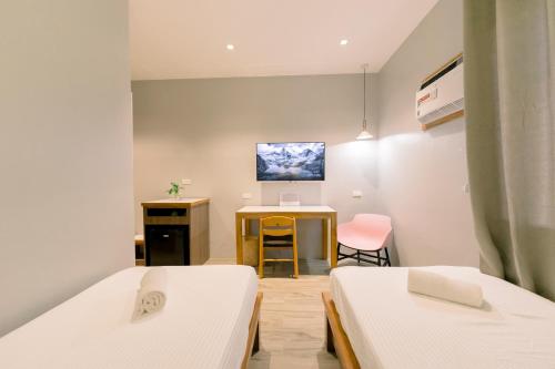 PanaboMadonna Hometel and Suites New Pandan的客房设有两张床和一台墙上的电视。