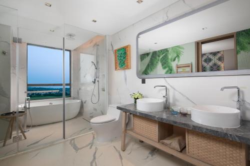 琼海琼海官塘假日度假酒店（尊享无限次温泉体验）的一间带两个盥洗盆和大镜子的浴室