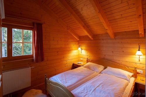 ElsenbrunnKuhglück Koralpe的小木屋内一间卧室,配有一张床