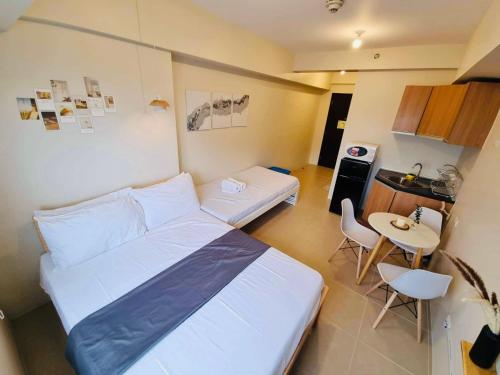 大雅台Nordic Bleu Staycation at Ayala Serin的配有床和桌子的房间以及厨房