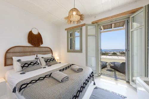 帕罗斯岛Parian Philoxenia Villa, Santa Maria Beach的一间卧室设有一张床和一个大窗户