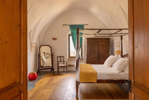 奥斯图尼Masseria San Paolo Grande的一间卧室配有天蓬床和镜子